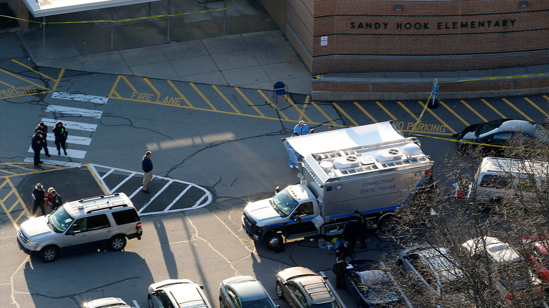 In this Dec. 14, 2012 aerial file photo, officials stand outside of Sandy Hook Elementary School where authorities say gunman Adam Lanza opened fire inside.